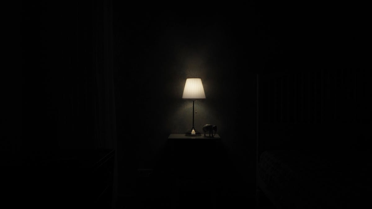 Lampe à poser allumée diffusant une lueur chaude dans une pièce sombre